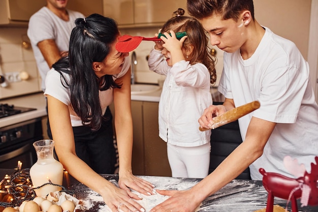 Família feliz se diverte na cozinha e preparando comida.