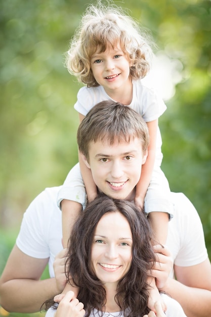 Família feliz se divertindo ao ar livre contra fundo verde primavera