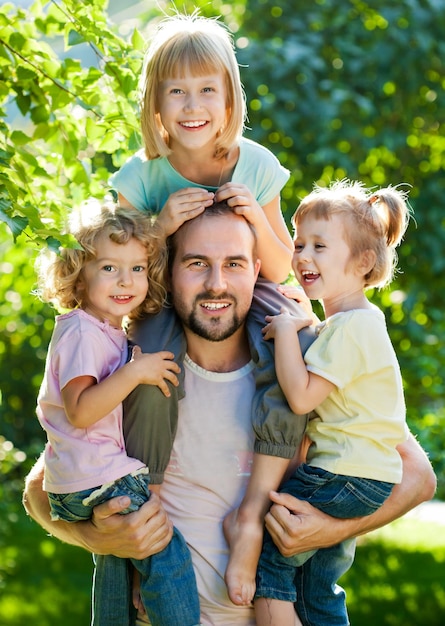 Família feliz se divertindo ao ar livre no parque primavera contra fundo verde natural