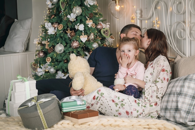 Família feliz se divertindo com presentes de natal em casa