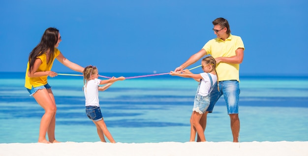 Família feliz se divertindo na praia branca