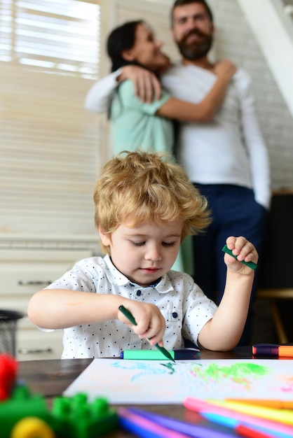 Família feliz se divertindo pais e criança brincando juntos Filho alegre desenhando com pai e mãe gostando de passar o tempo Criança aprendendo a pintar desenho de pintura de pequeno artista