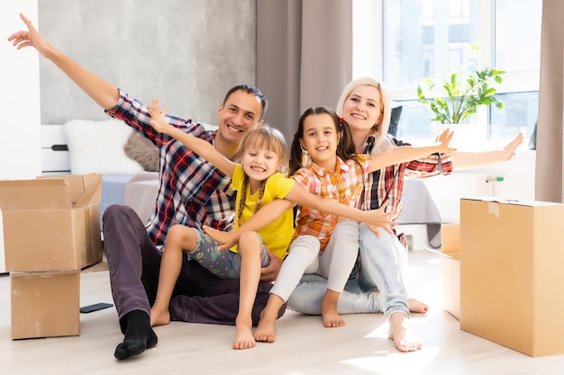 Família feliz se mudando para casa com caixas ao redor