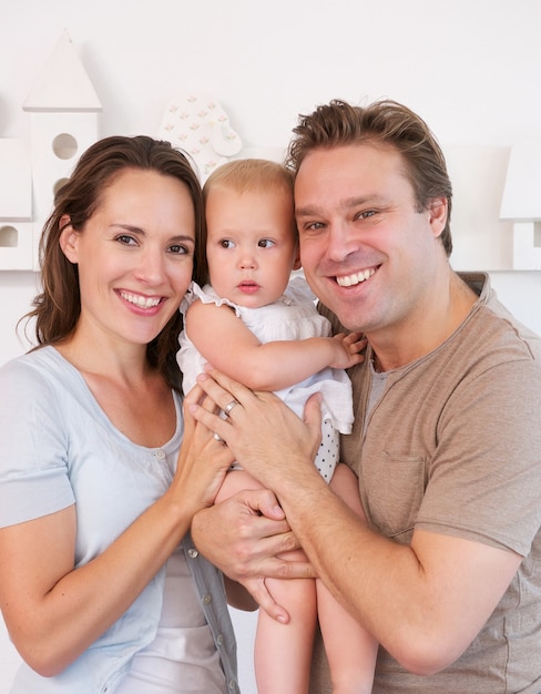 Família feliz segurando bebê fofo em casa