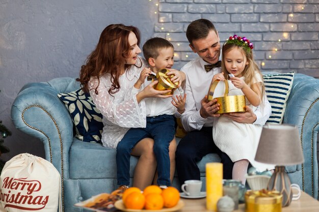 Família feliz, segurando o presente de Natal, olhando para a câmera