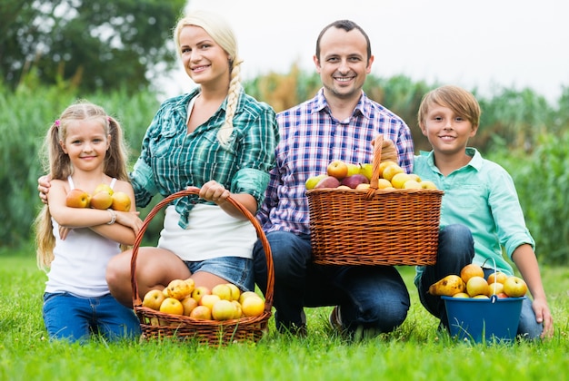 Família feliz segurando uma cesta com maçãs