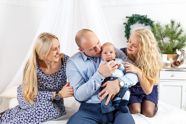 Familia feliz sentada en la cama