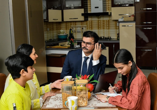 família feliz sentada na mesa de jantar modelo indiano do paquistanês