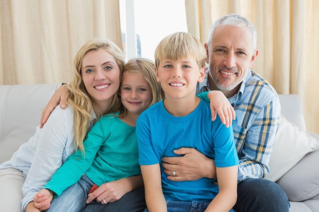 Família feliz sentada no sofá juntos