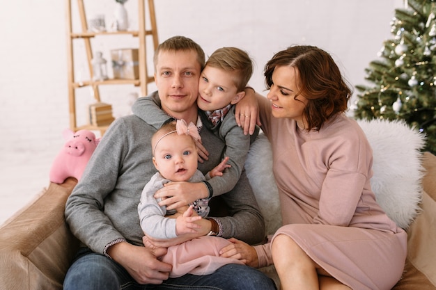 Família feliz sentada no sofá Retrato tradicional de Natal