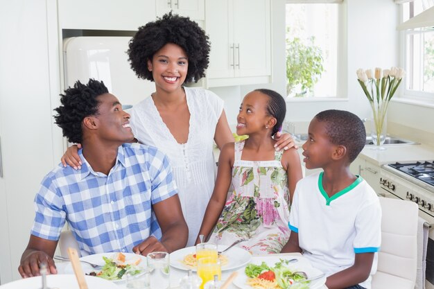 Família feliz sentada para jantar juntos