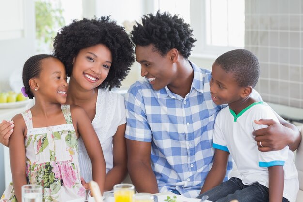 Família feliz sentada para jantar juntos