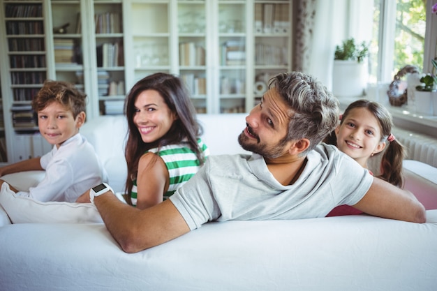 Familia feliz sentada en el sofá