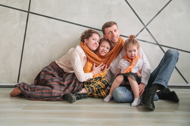 Familia feliz sentada en el suelo en apartamento nuevo.