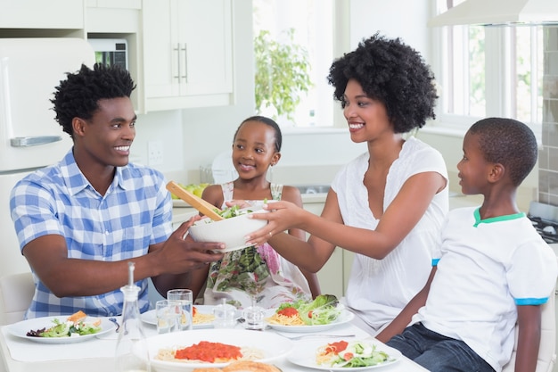 Familia feliz sentado a cenar juntos