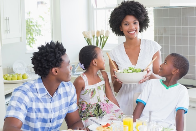 Familia feliz sentado a cenar juntos