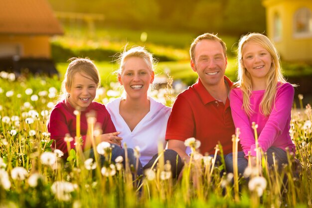 Família feliz sentado no Prado de verão