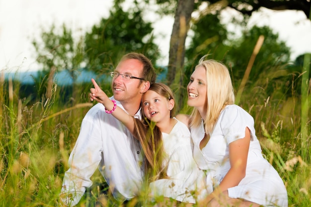 Família feliz sentado no Prado