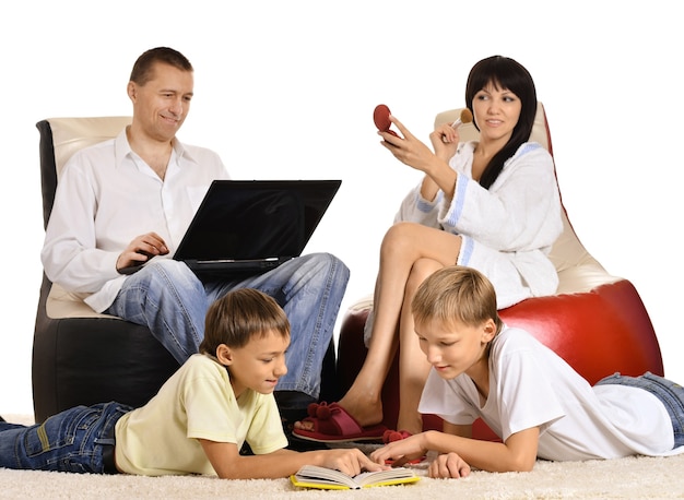 Familia feliz sentado en una silla con una computadora portátil