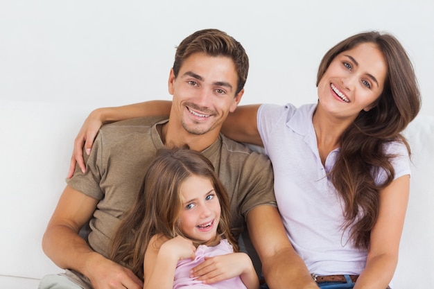 Familia feliz sentados juntos en un sofá