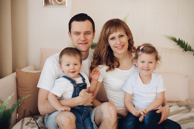 Familia feliz se sienta en la sala de luz y pasa tiempo juntos