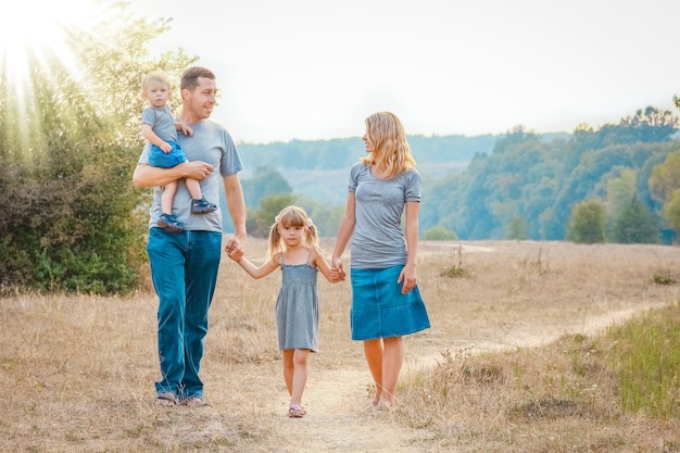 Familia feliz sobre la naturaleza de los niños descansa con el fondo de la carretera