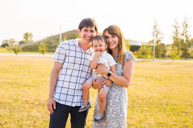 Familia feliz sonriendo a la cámara en un día soleado.