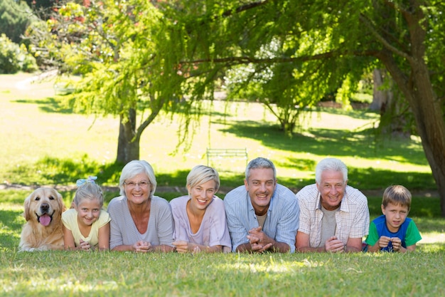 Familia feliz sonriendo a la cámara con su perro