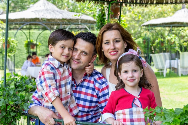 Familia feliz sonriendo con niños con árboles