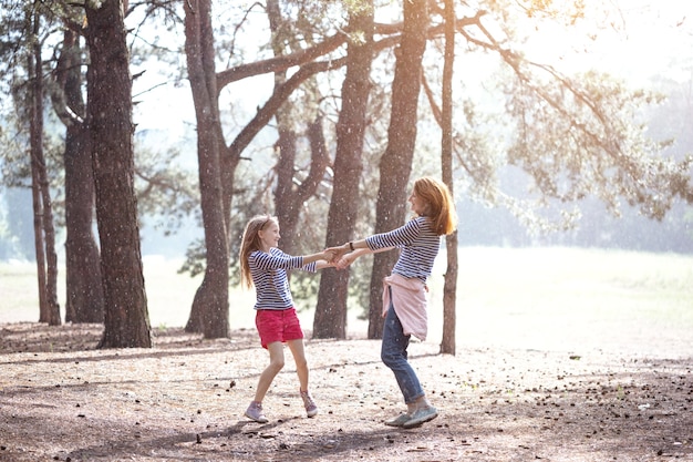 Familia feliz - sonriente madre e hija en un paseo al atardecer