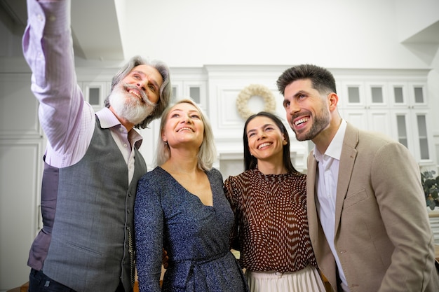 Família feliz sorrindo, pais e um jovem casal tirando uma selfie no smartphone do avô