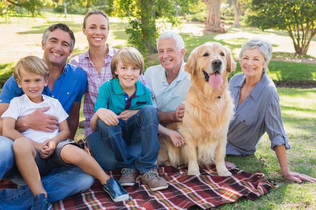 Foto família feliz sorrindo para a câmera com seu cachorro