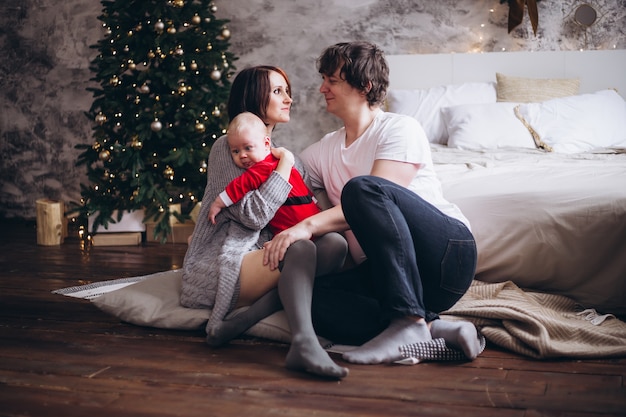 Familia feliz con su bebé en Navidad