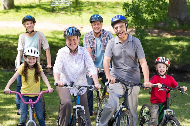 Familia feliz en su bicicleta en el parque en un día soleado