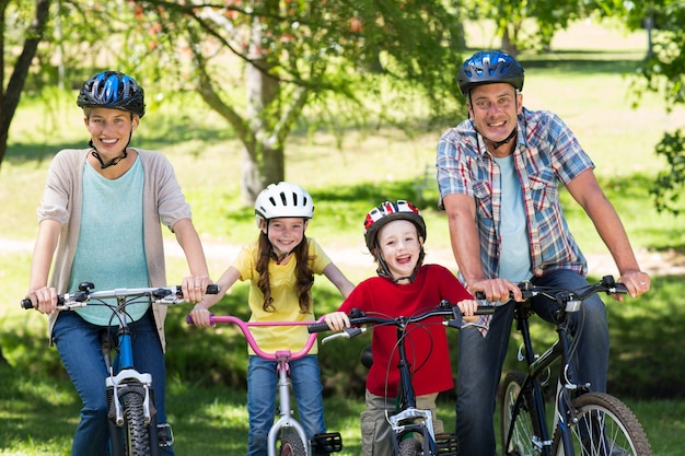 Familia feliz en su bicicleta en el parque