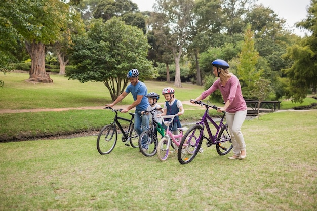 Familia feliz en su bicicleta en el parque