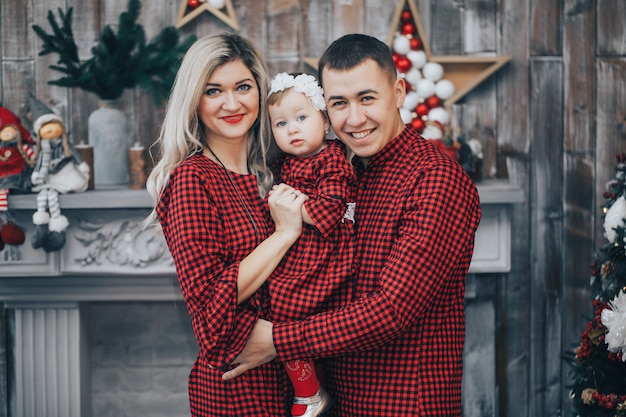 Familia feliz con su pequeña hija juntos en habitación decorada