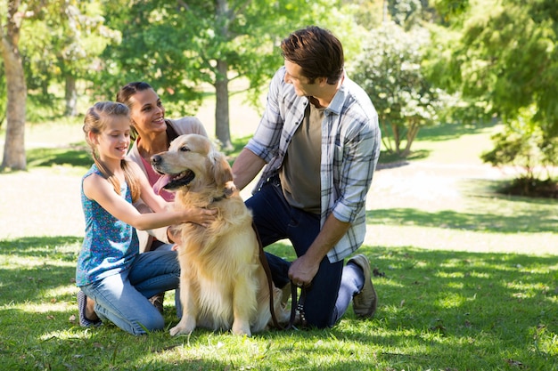 Familia feliz con su perro en el parque