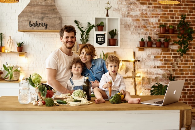 Familia feliz con sus hijos cocinando en la cocina