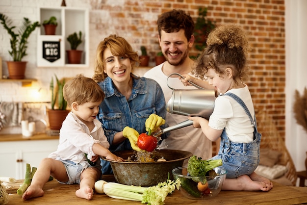 Familia feliz con sus hijos cocinando en la cocina