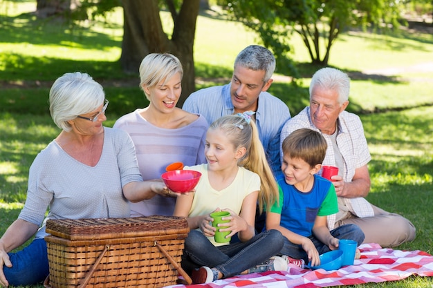 Família feliz tendo piquenique no parque