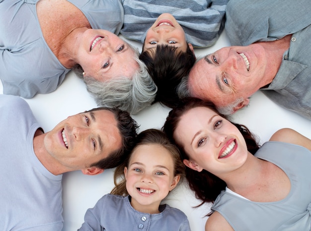 Foto familia feliz tirado en el piso con las cabezas juntas