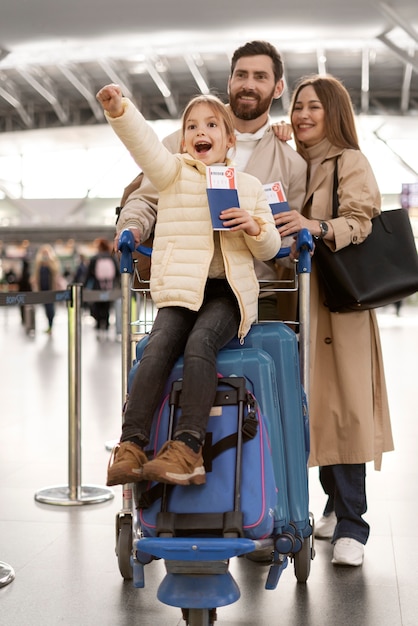 Foto familia feliz de tiro completo en el aeropuerto