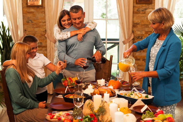 Familia feliz de tiro medio en la cena