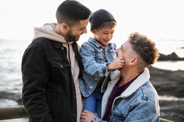 Familia feliz de tiro medio en la playa