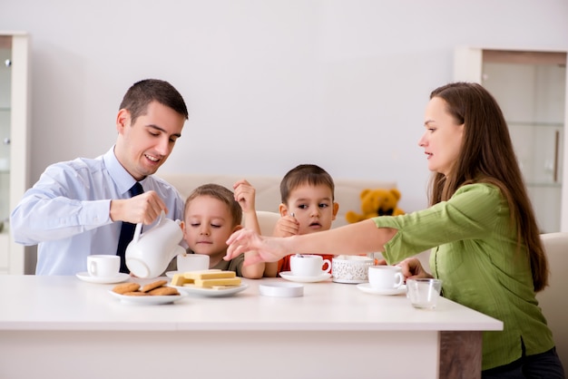 Família feliz tomando café juntos em casa