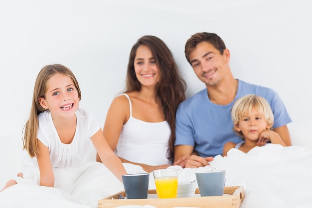 Familia feliz tomando el desayuno en la cama