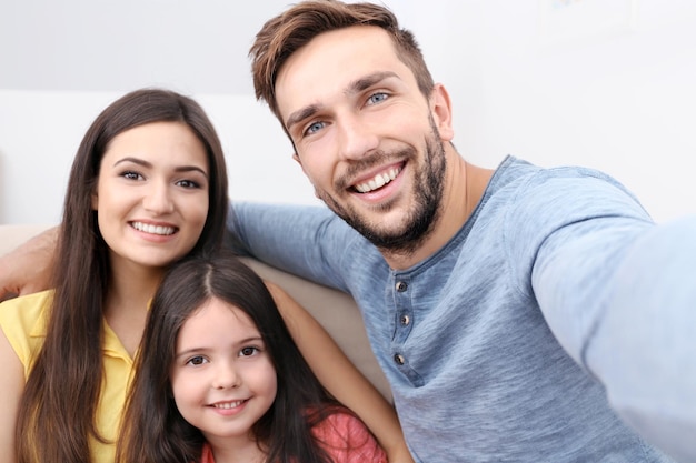 Foto familia feliz tomando selfie en casa