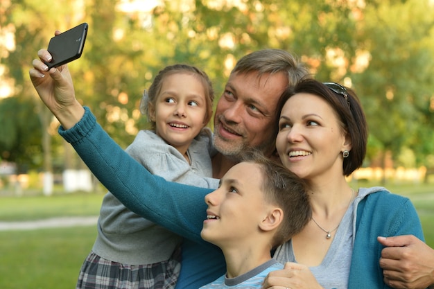 Familia feliz tomando selfie en un parque