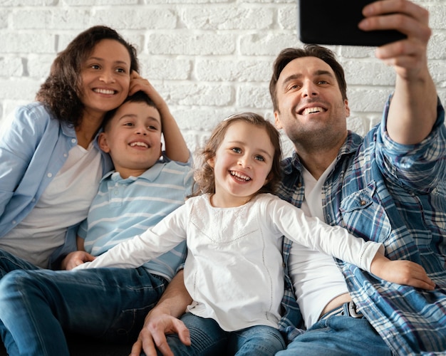 Foto familia feliz tomando selfies tiro medio